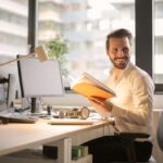 A relaxed businessman enjoying a break in his bright, contemporary office environment.