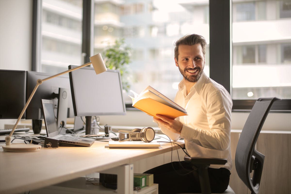 A relaxed businessman enjoying a break in his bright, contemporary office environment.