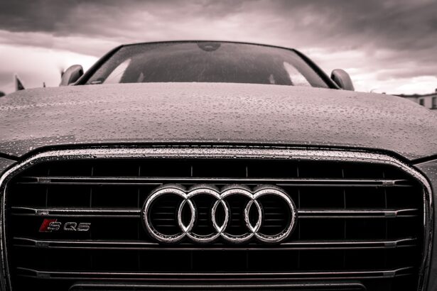 Αυτοκίνητο Audi στον δρόμο υπό βροχή με τον σήμερα της εταιρείας στον προφυλακτήρα