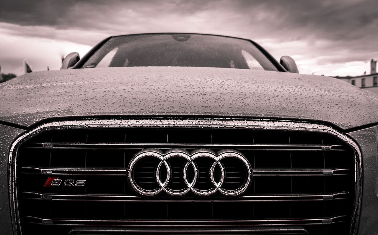 Αυτοκίνητο Audi στον δρόμο υπό βροχή με τον σήμερα της εταιρείας στον προφυλακτήρα