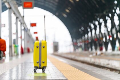 Κίτρινη βαλίτσα σε σιδηροδρομικό σταθμό