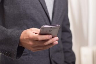 Επιχειρηματίας με το κινητό τηλέφωνο στο χέρι