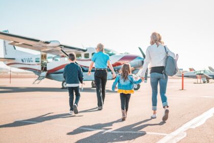 German family with children at airport preparing for summer holiday trip