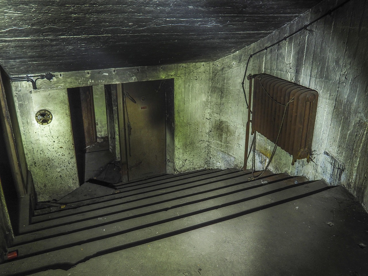 Reinforced bunker door in a basement designed as protective shelter