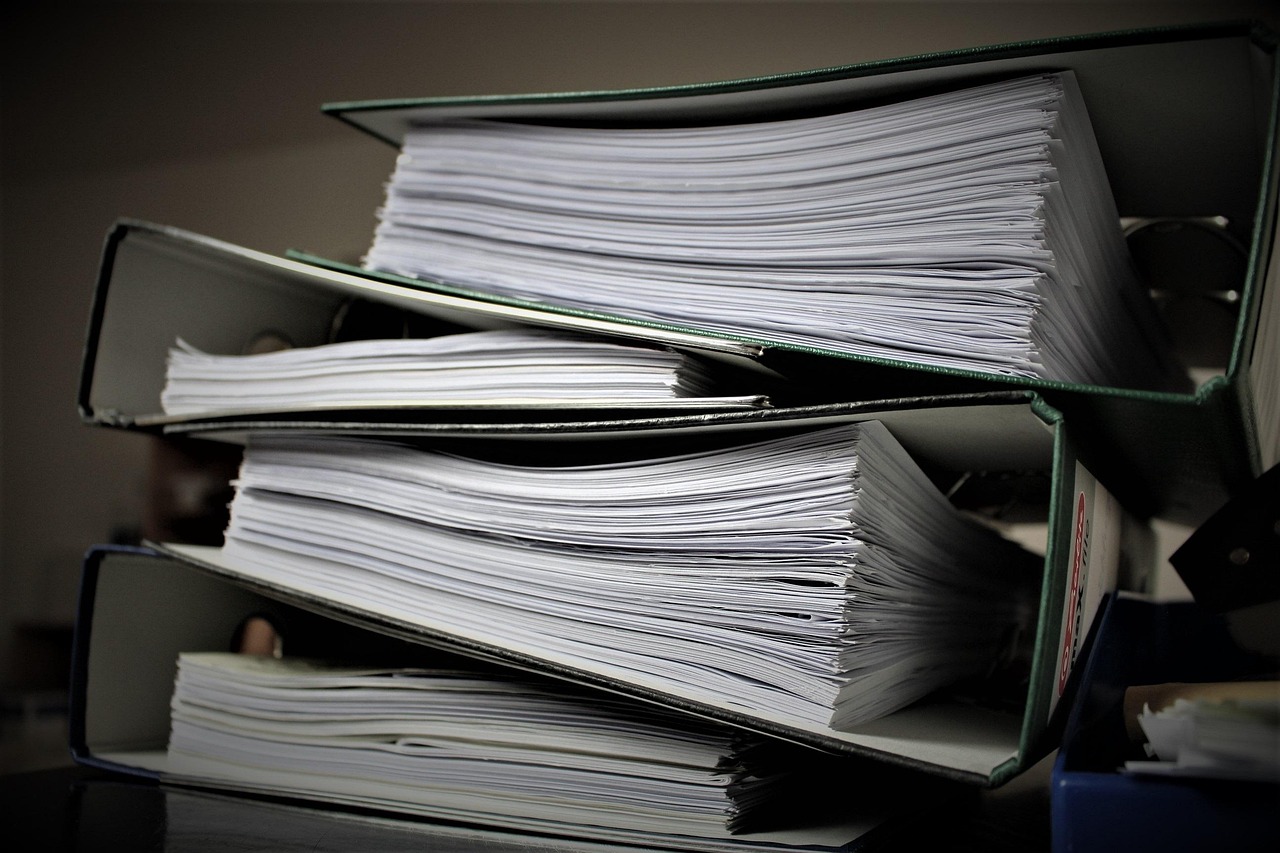 Stacks of documents on a desk in a German office illustrating bureaucracy burden