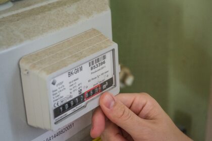 German household reviewing gas meter and utility bills
