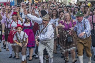 Visitors at Munich Oktoberfest fanning themselves in crowded tent during record heat