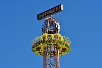 Jules Verne Tower swing carousel at Oktoberfest in Munich lit up at night