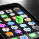 Smartphone with WhatsApp and Signal apps in front of EU flag symbolizing surveillance debate