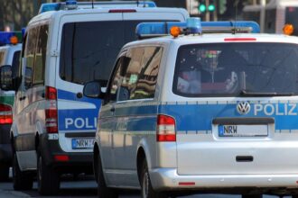 Police vehicles and officers outside Frankfurt police station during misconduct investigation