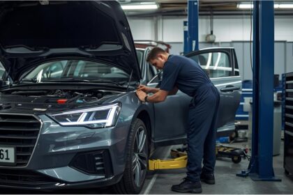 Mechanic working on car in German repair shop as insurance costs rise