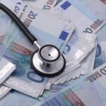 German payslip with euro coins representing rising health insurance contributions