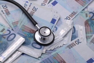 German payslip with euro coins representing rising health insurance contributions