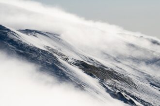 Snowless ski slopes in the Bavarian Alps under clear winter sky