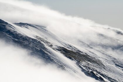 Snowless ski slopes in the Bavarian Alps under clear winter sky