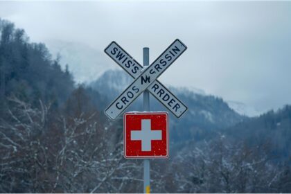 Swiss border sign covered in snow symbolising new asylum travel restrictions