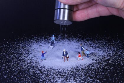 Winter service vehicles in Munich clearing a snow-covered street during early morning hours.