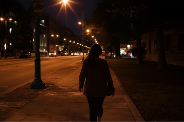 Woman walking alone on a quiet, dimly lit city street at night under streetlights